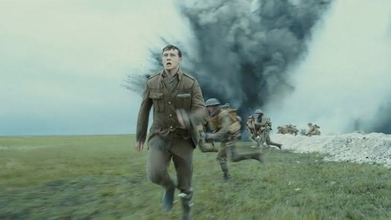 Personagem de 1917 correndo das bombas em cena de guerra do filme - Universal Pictures