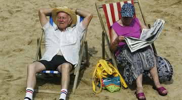 Idosos na praia em dia de sol - Getty Images